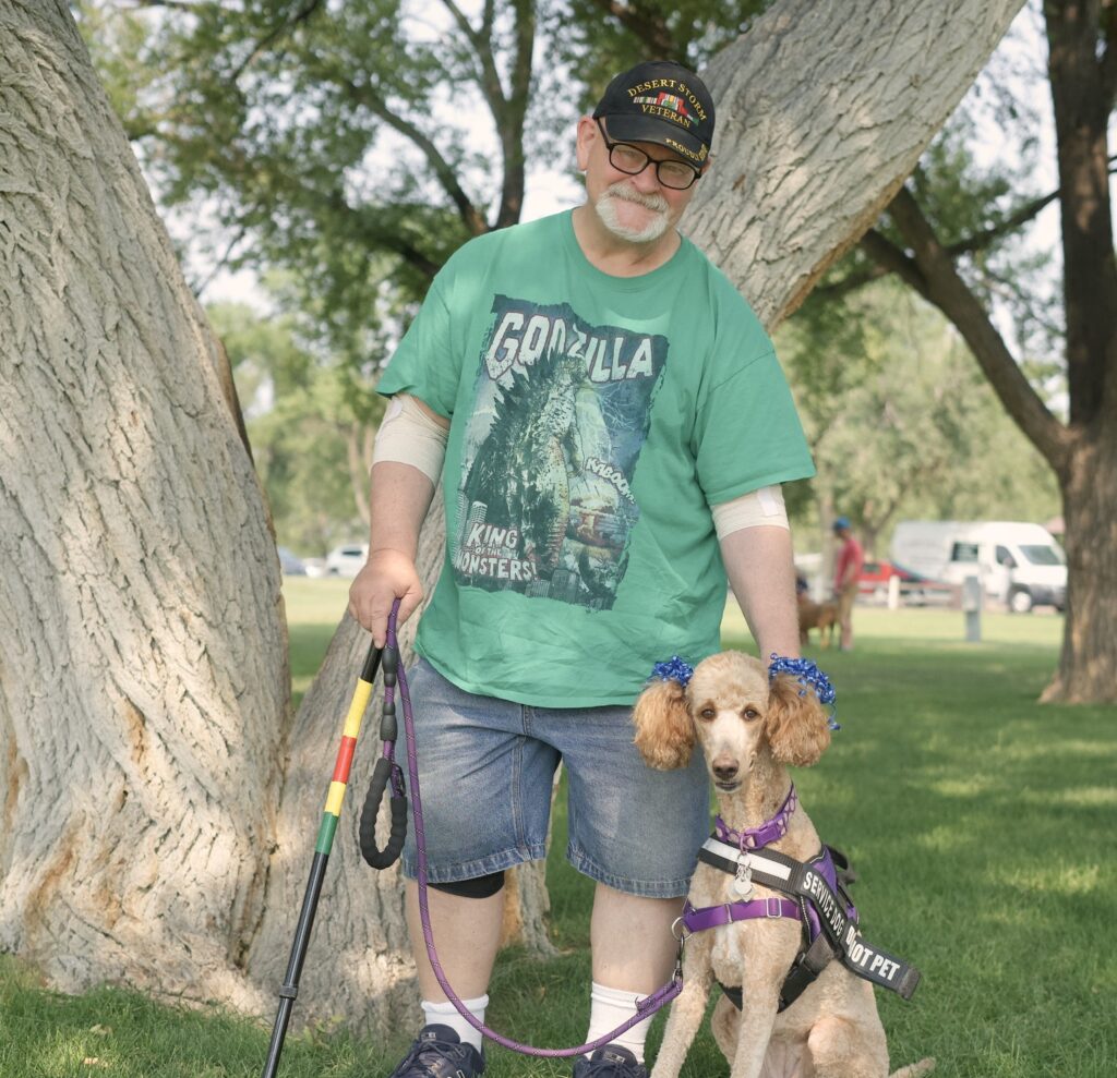 a person with a cane standing with a service dog
